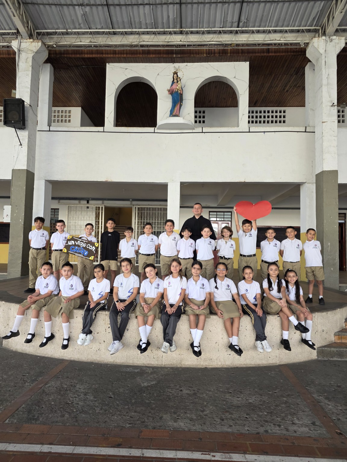 Fotografía grupal de estudiantes y sacerdote salesiano