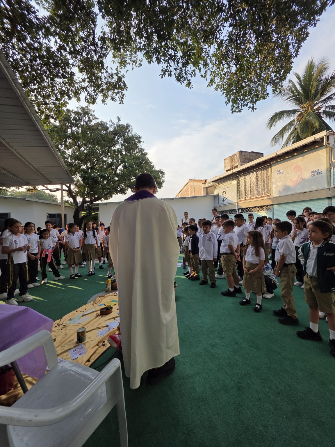 Momento pastoral con sacerdote y estudiantes al aire libre